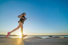 Jeune fille sportive seul courant au beau coucher du soleil sur la plage 75294648